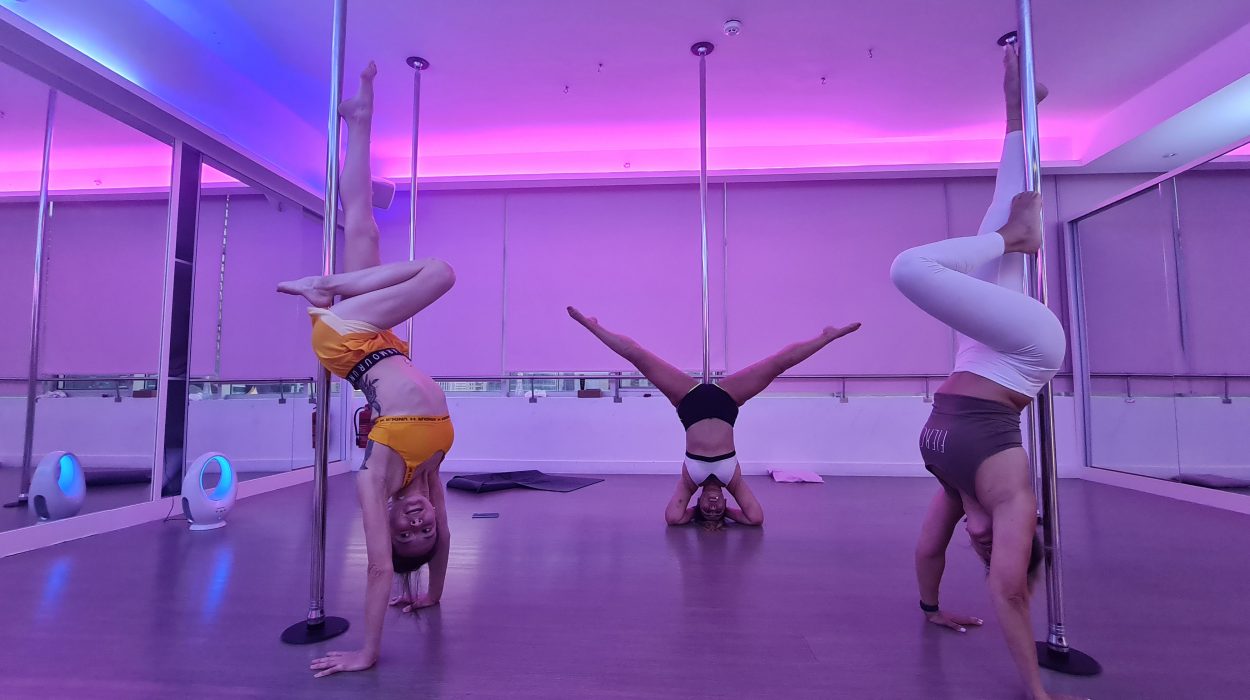 three woman at a pole fitness class