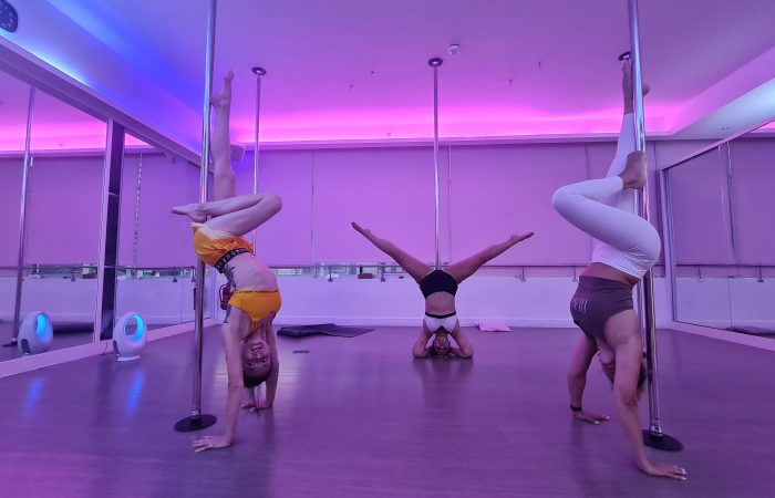 three woman at a pole fitness class